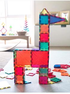 a colorful object is sitting on the floor in front of a window and toys are scattered around it