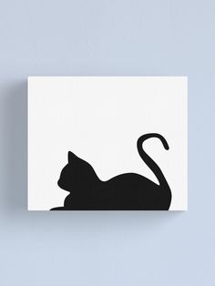 a black cat silhouetted on a white background with the tail curled up canvas print