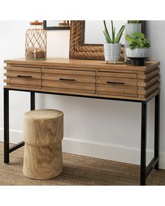 a wooden table topped with a mirror next to a plant and a potted plant