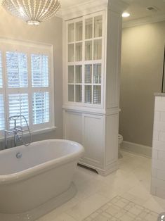 a large white bath tub sitting in a bathroom next to a walk - in shower