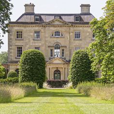 a large stone building surrounded by trees and bushes