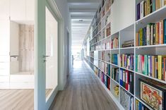 the bookshelves are lined up along the wall in this long hallway that leads to another room