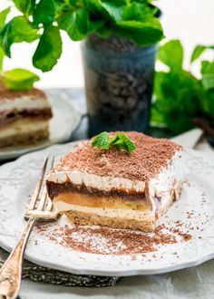 a piece of cake sitting on top of a white plate next to a potted plant