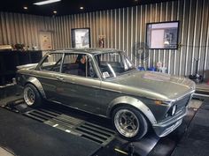 an old car is on display in a garage