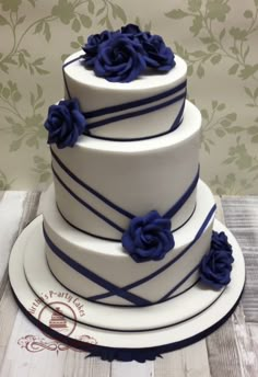 a three tiered cake with blue flowers on top