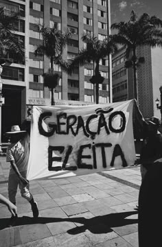 a man holding a sign that says geracao ezetta