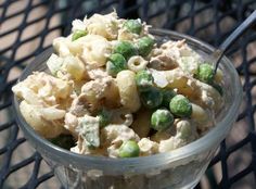 a glass bowl filled with macaroni salad on top of a metal grill grate