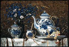 blue and white vases with flowers in them on a mosaic tile table top by a brick wall