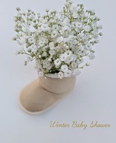 small white flowers are in an old boot