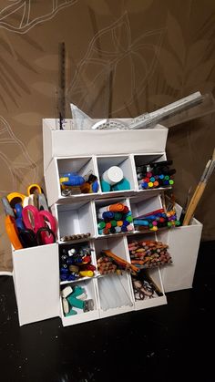 an assortment of crafting supplies sitting on top of a table next to a wall