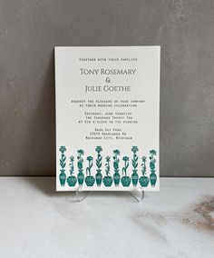 a wedding card with cactus silhouettes on the front and back, in teal green ink