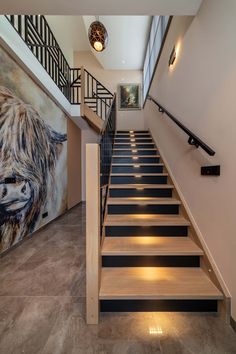 a staircase with black and white striped treading next to a painting on the wall