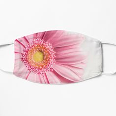 a pink and yellow flower on a white face mask that is designed to look like a daisy