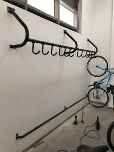 there is a bike hanging on the wall next to some hooks and hoses that are attached to the wall