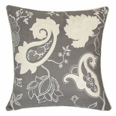 a gray and white pillow with flowers on it