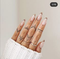 a woman's hand with tattoos on her fingers and fingernails in the shape of arrows