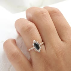 a woman's hand with a black and white diamond ring