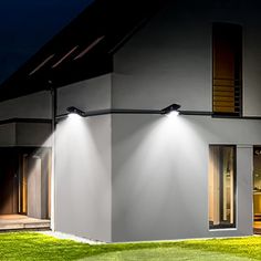 an image of a house that is lit up at night with two lights on it