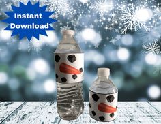 two water bottles sitting next to each other on top of a wooden table with snowflakes in the background