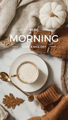 a cup of coffee sitting on top of a white plate next to a gold spoon