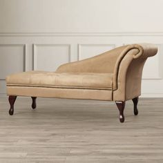 an old style chaise lounger in a room with wood floors and white walls