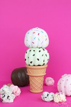 three ice cream cones with sprinkles and chocolate covered donuts on top