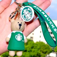 a starbucks keychain with a small teddy bear attached to it's neck