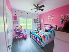 a child's bedroom decorated in pink, blue and green