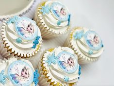 cupcakes decorated with frosting and icing are displayed on a table top