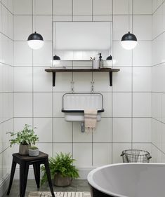 a bath room with a tub a sink and two lights on the wall above it