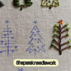 some little trees are sitting on a table cloth with words in the middle and one is made out of beads