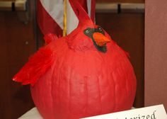 a red bird sitting on top of a white table next to an american flag in the background