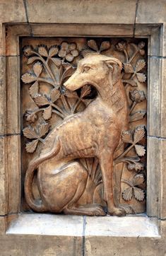 a carving of a dog on the side of a building