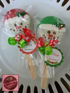 two lollipops wrapped in cellophane and decorated with bows on a plate