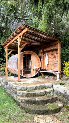 a wooden barrel sitting in the middle of a yard next to some steps and trees