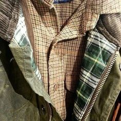 the jacket is green, brown and white checkered with a blue tag on it