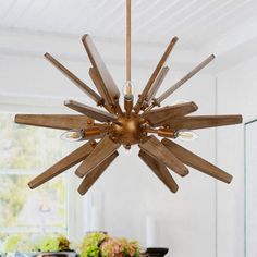 a wooden chandelier hanging from the ceiling in a dining room with white walls