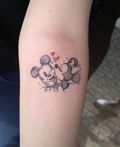 a tattoo on the arm of a person with mickey and minnie mouses head tattoos