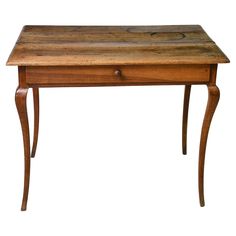 an old wooden table with one drawer on the top and two legs at the bottom