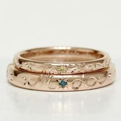 two gold wedding bands with blue and green stones