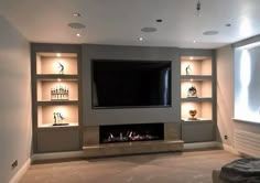 a living room with built in shelves and a flat screen tv mounted on the wall