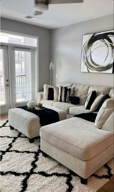 a living room with white furniture and black accents