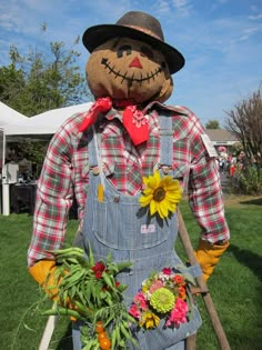 a scarecrow with sunflowers in his hands