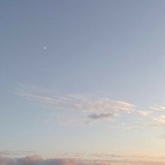 two people are flying kites on the beach at sunset or sunrise, with clouds in the background