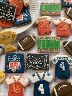 decorated cookies are laid out on a table to look like sports jerseys and footballs