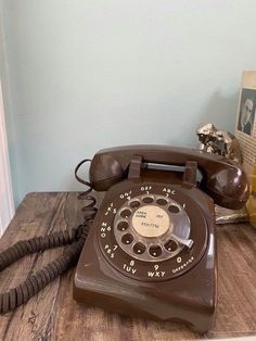 an old fashioned telephone sitting on a wooden table