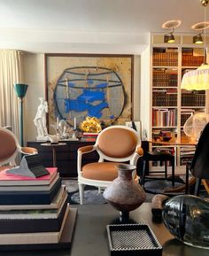 a living room filled with lots of furniture and books