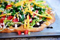 a pizza topped with lettuce, black beans and cheese