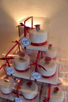 there are many small cakes with red ribbons on them