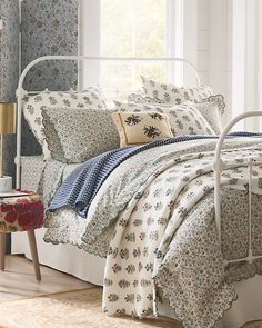 a bed with white metal headboard and foot board in a bedroom next to a window